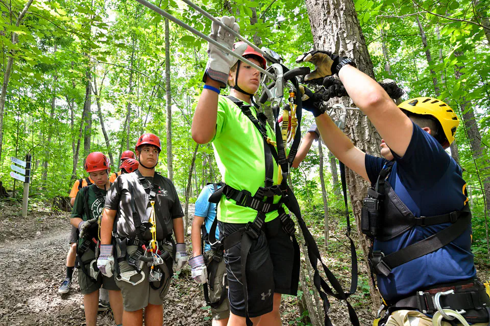 students being assisted before climbing